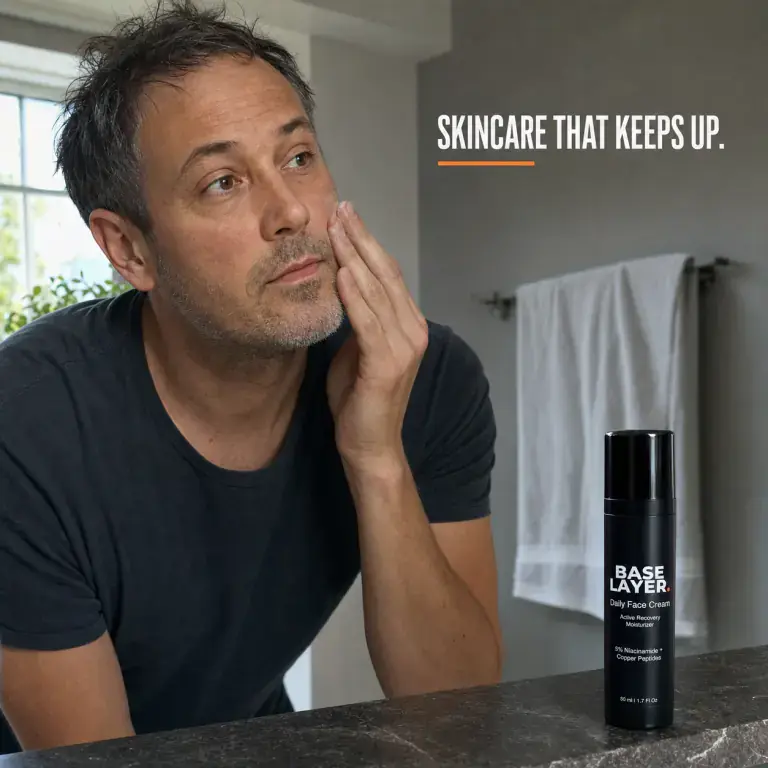 Man applying Base Layer face cream in morning bathroom light
